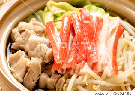 一人前サイズの小さな土鍋に入れられた、かにかまぼこと鶏肉の鍋。 一人前サイズの小さな土鍋に入れられた、かにかまぼこと鶏肉の鍋。 75002480