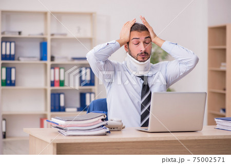 Young neck injured male employee working in the office 75002571