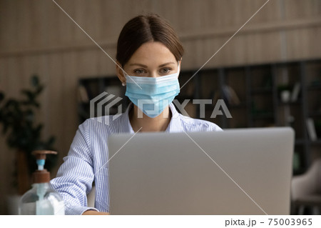 Businesswoman in facemask work on laptop online Businesswoman in facemask work on laptop online 75003965