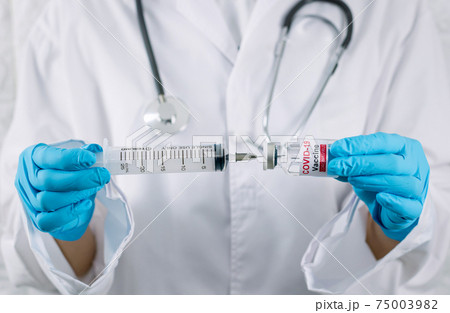 Doctor with a stethoscope holding vaccine syringe of coronavirus 75003982