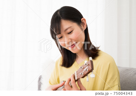 家でウクレレを演奏する女性 75004343