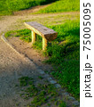 Old wooden bench made from a tree trunk in a park 75005095
