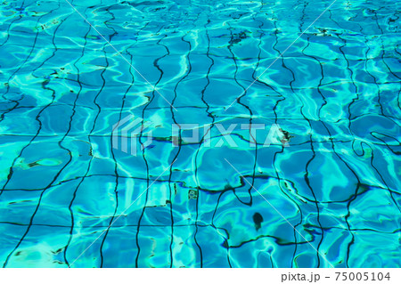 Blue and bright water in a swimming pool with sun reflection Blue and bright water in a swimming pool with sun reflection 75005104