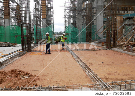 KUALA LUMPUR, MALAYSIA -JULY 30, 2020: Construction workers mixing and spraying the anti termite chemical treatment to the soil at the construction site. KUALA LUMPUR, MALAYSIA -JULY 30, 2020: Construction workers mixing and spraying the anti termite chemical treatment to the soil at the construction site. 75005692