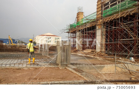 KUALA LUMPUR, MALAYSIA -JULY 30, 2020: Construction workers mixing and spraying the anti termite chemical treatment to the soil at the construction site.  75005693