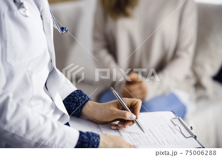 Unknown woman-doctor and patient discussing current health examination while sitting indoors. Stay at home concept during Coronavirus pandemic and self isolation quarantine 75006288
