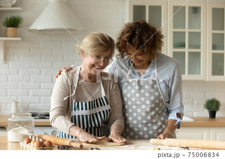 Adult daughter and retired mom make dough for bakery together Adult daughter and retired mom make dough for bakery together 75006834