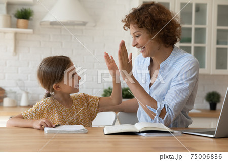 Excited mother give high five to small daughter praise child Excited mother give high five to small daughter praise child 75006836