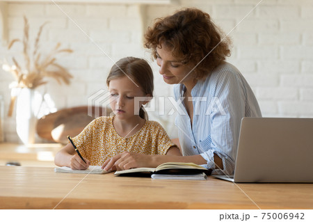 Young woman tutor giving private lesson to little girl pupil 75006942