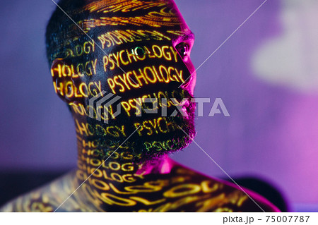 Young adult man with words Psychology on his face in the dark. Young adult man with words Psychology on his face in the dark. 75007787
