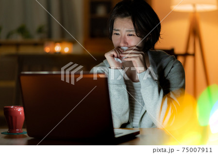 深夜リビングで映画を見ながら号泣する若い女性 深夜リビングで映画を見ながら号泣する若い女性 75007911
