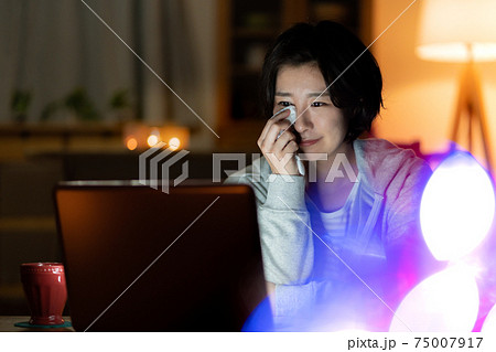 深夜リビングで映画を見ながら号泣する若い女性 深夜リビングで映画を見ながら号泣する若い女性 75007917