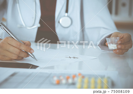 Unknown woman-doctor fills up prescription form. close-up. Panacea and life save, prescribe treatment, legal drug store. Medicine concept Unknown woman-doctor fills up prescription form. close-up. Panacea and life save, prescribe treatment, legal drug store. Medicine concept 75008109