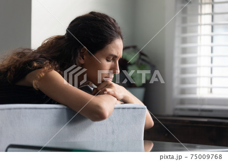 Close up upset thoughtful woman lying on couch alone 75009768