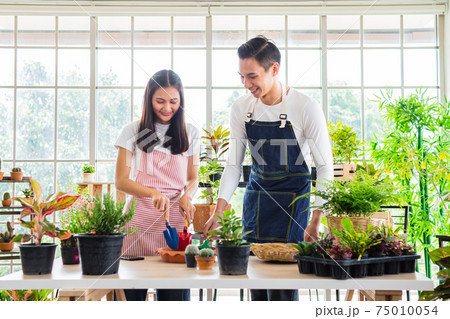 asia handsome man and beautiful woman taking care of her potted plants at home asia handsome man and beautiful woman taking care of her potted plants at home 75010054