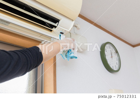 エアコンとカーテンレールをそうじする女性の手元 75012331