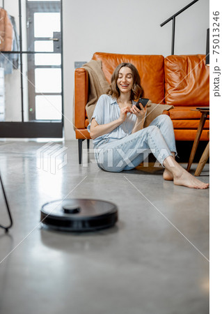 Robotic vacuum cleaner cleaning the room at home 75013246