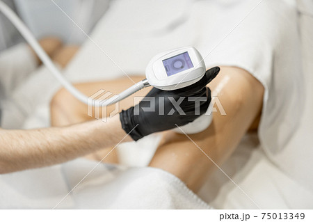 Doctor doing ultrasound liposuction procedure in medical clinic. Doctor doing ultrasound liposuction procedure in medical clinic. 75013349