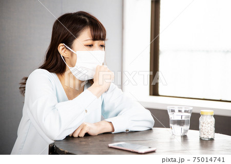 マスクをした体調不良の若い女性 75014741
