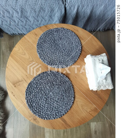 Grey round napkins on a wooden table 75015726