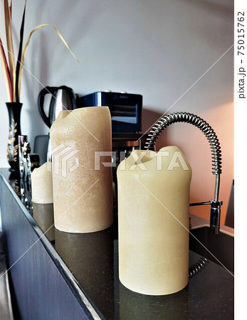 Three beige candles on the kitchen table 75015762