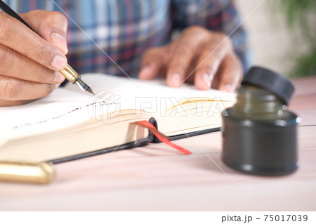 Close up of man hand writing a letter with fountain pen  75017039