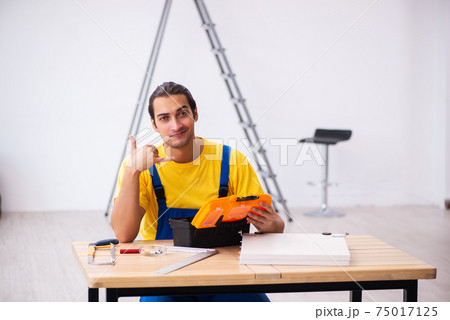 Young male carpenter working indoors Young male carpenter working indoors 75017125