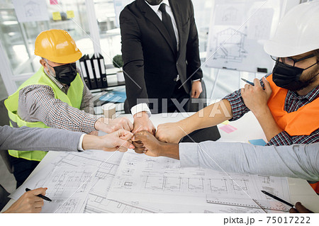 Business partners in masks bumping with fists Business partners in masks bumping with fists 75017222