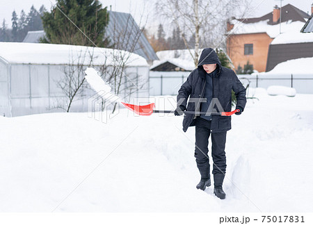 Adult man shoveling snow Adult man shoveling snow 75017831