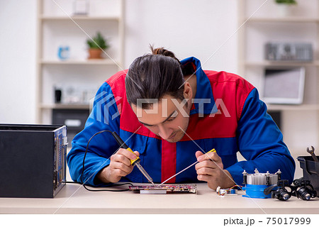 Young male repairman repairing computer Young male repairman repairing computer 75017999