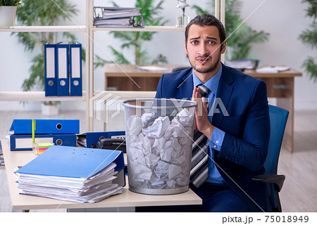 Young businessman employee rejecting new ideas with lots of pape Young businessman employee rejecting new ideas with lots of pape 75018949