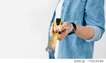 Carpenter, handyman, construction with tape-line and engineer size measuring for repair Carpenter, handyman, construction with tape-line and engineer size measuring for repair 75019288