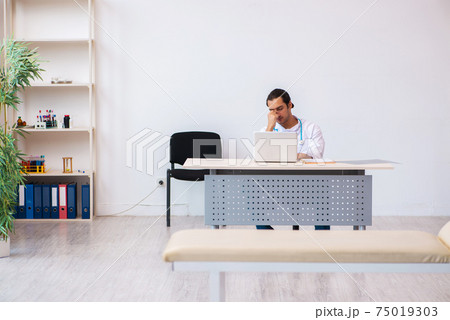 Young male doctor working in the clinic Young male doctor working in the clinic 75019303