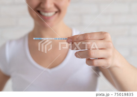 Happy woman shows a negative ovulation test. The concept of female fertility and luteinizing hormone. Not the right time to conceive a baby. Happy woman shows a negative ovulation test. The concept of female fertility and luteinizing hormone. Not the right time to conceive a baby. 75019835