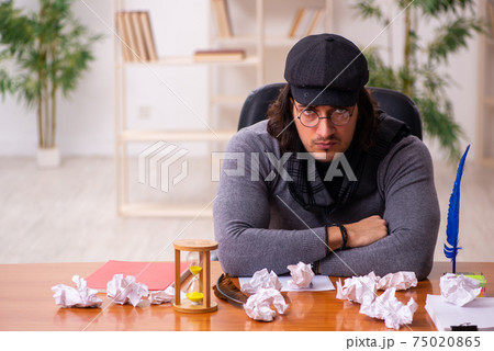 Young male writer in time management concept 75020865