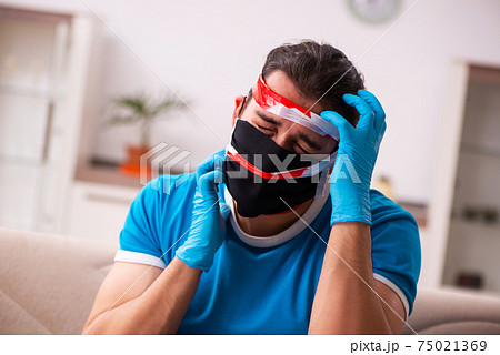 Roped young man being unhappy at home in quarantine concept Roped young man being unhappy at home in quarantine concept 75021369