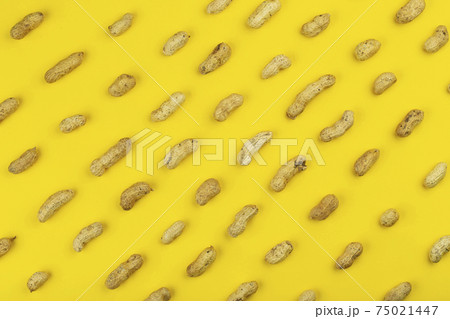 Peanuts pattern isolated on a yellow backround. Repetition concept. Peanuts pattern isolated on a yellow backround. Repetition concept. 75021447