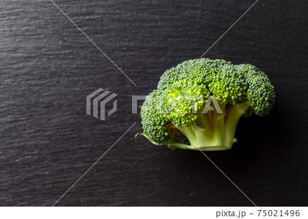 Fresh broccoli on a black cutting board. Healthy food concept. Fresh broccoli on a black cutting board. Healthy food concept. 75021496