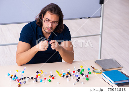 Young male scientist sitting in the classroom Young male scientist sitting in the classroom 75021818