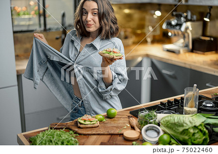 Happy slim woman showing her weight loss 75022460