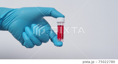 Blood tube. Covid 19 Test. doctor hand holding a blood sample tube for analysis in the lab background. Technician in medical gloves holding blood tube test for research vaccine protect virus infected. 75022780