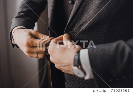 man in business suit buttoning button man in business suit buttoning button 75023561