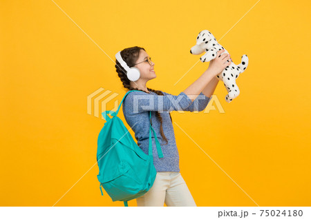 Learning through play. Happy girl play with soft dog. 75024180