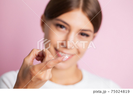 Close-up shot of young woman wearing contact lens. 75024819