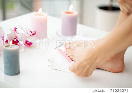 Cheerful Girl Doing Nails Making Pedicure Sitting In Bed Indoor. 75026075