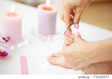 Cozy home spa, young woman doing pedicure on her feet nails. 75026077