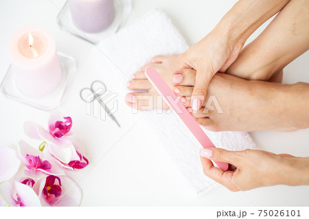 Cheerful Girl Doing Nails Making Pedicure Sitting In Bed Indoor. 75026101