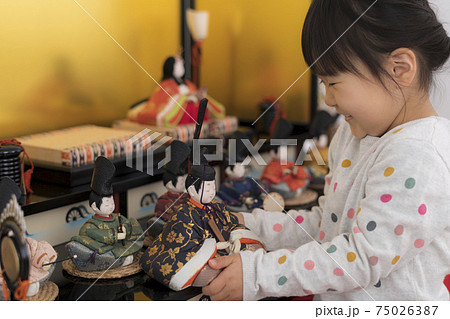 ひな祭りの準備を手伝う3歳の女の子(日本の伝統行事や風習) ひな祭りの準備を手伝う3歳の女の子(日本の伝統行事や風習) 75026387