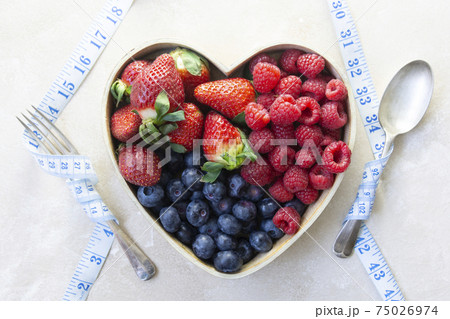 Dieting, healthy food. Assortment berries blueberries, strawberries and raspberries in heart woden box. Keto diet. Dieting, healthy food. Assortment berries blueberries, strawberries and raspberries in heart woden box. Keto diet. 75026974