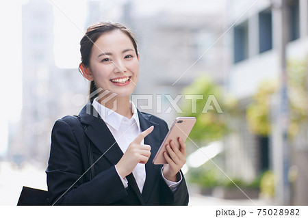 オフィス街でスマホを使用する就活中の大学生 75028982